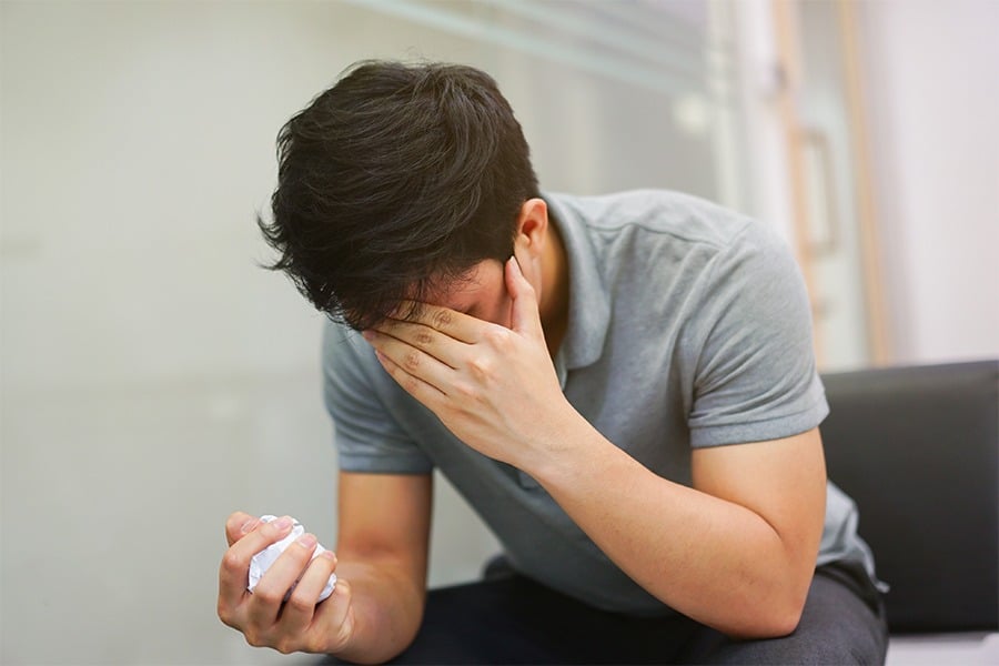 man covering face