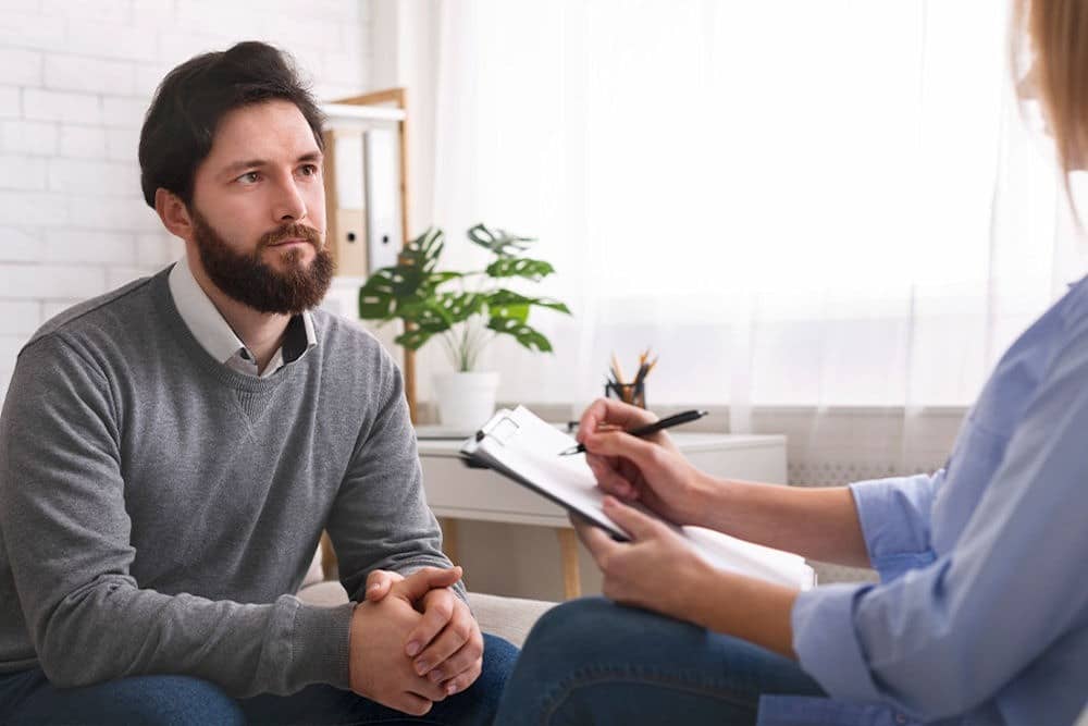 Man discussing Lexapro and alcohol interactions with a therapist during counseling